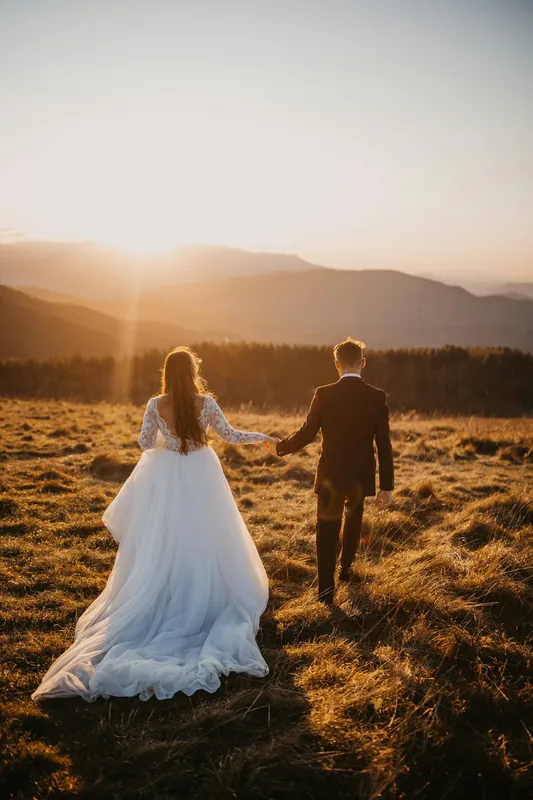 Novios caminando por un campo dorado