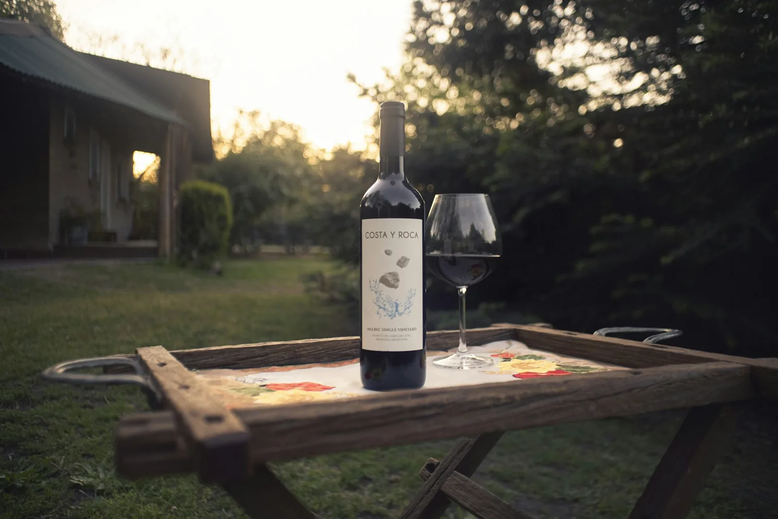 Botella y copa en una mesa de jardín