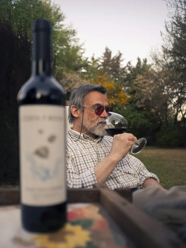 Hombre probando vino junto a la botella