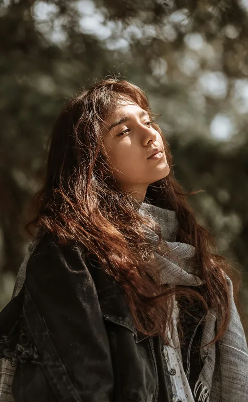 Retrato de mujer con luz dorada entre los árboles